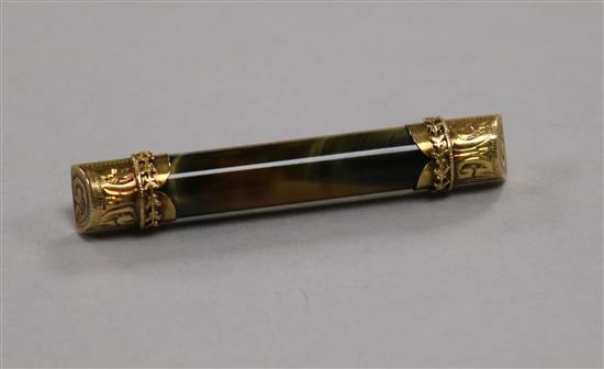 A tigers eye baton brooch with engraved 15ct gold mounts, 50mm.